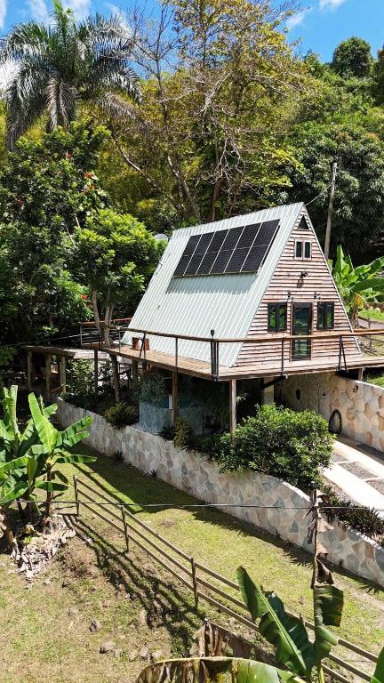 a house with solar panels on top of it at Hidden Cabins Puerto Rico in Comerio