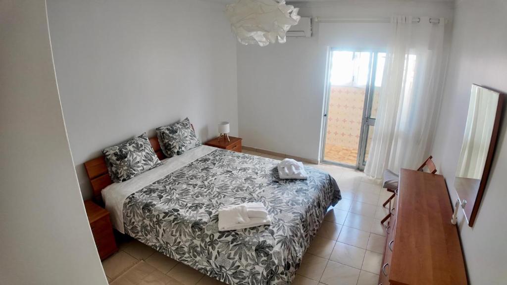 a bedroom with a bed and a window at Casa Inês in Fuzeta
