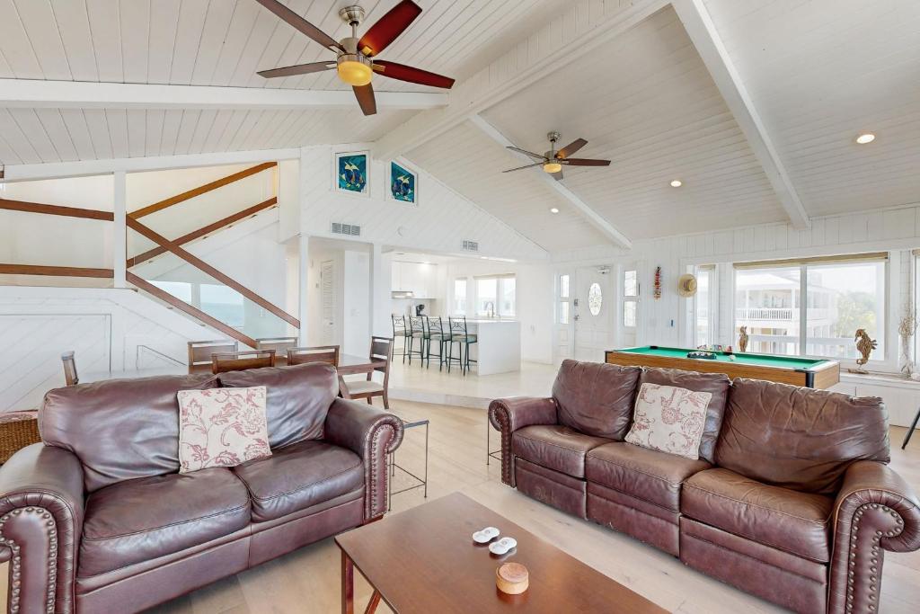 a living room with two leather couches and a pool table at CJ295FLR Hawkins Lookout in Cudjoe Key