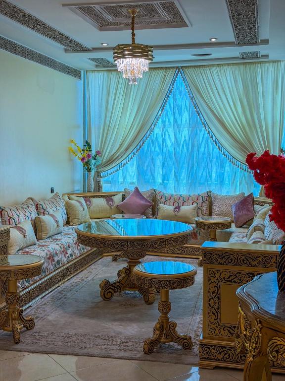 a living room with a couch and a table at Abraj Dubai - Premium 3BR Stay in Heart of Larache in Larache