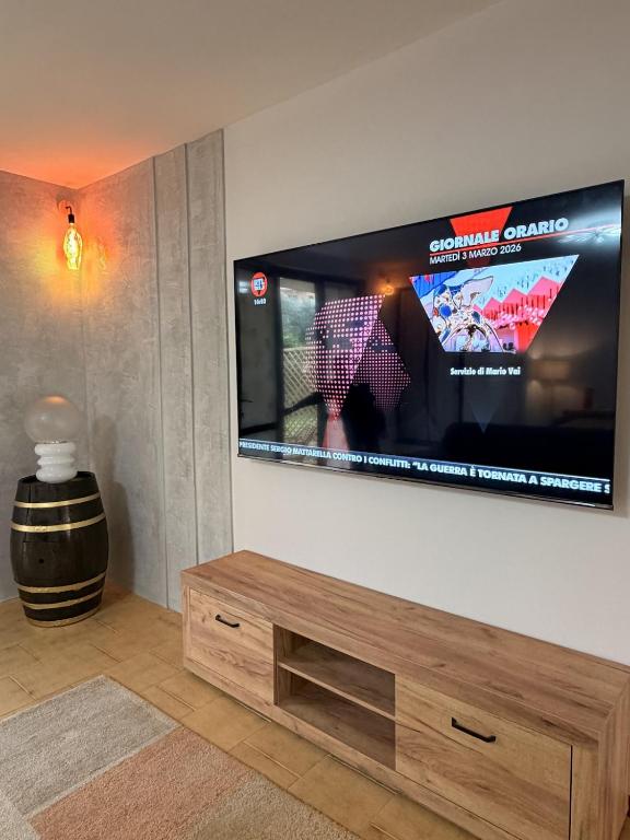 a living room with a large flat screen tv on a wall at Garda MarANDGi Home Salo' in Salò