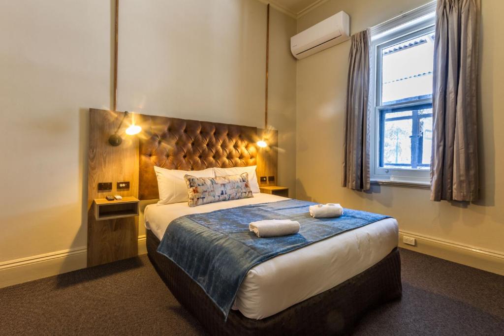 a bedroom with a large bed and a window at Pretoria Hotel in Mannum