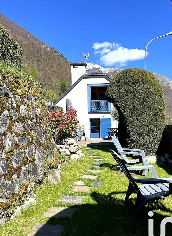 a couple of benches sitting in front of a house at Entre ciel et montagnes in Cauterets
