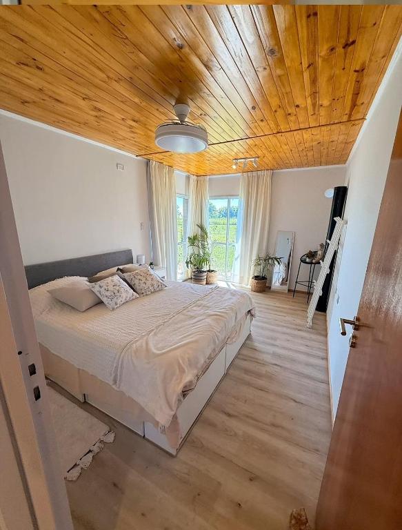a bedroom with a large bed and a wooden ceiling at Casa de campo ElChale cerca del autodromo de Rafaela in Rafaela