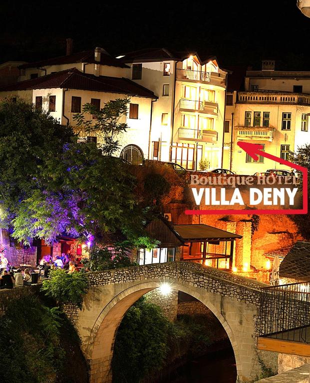a bridge over a river in front of a building at "VILLA DENY" Boutique HOTEL - with FREE PARKING in Mostar