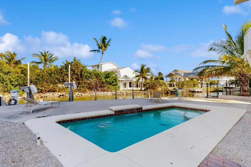 a swimming pool in front of a house at CJ314FLR The Mermaid Manor in Cudjoe Key
