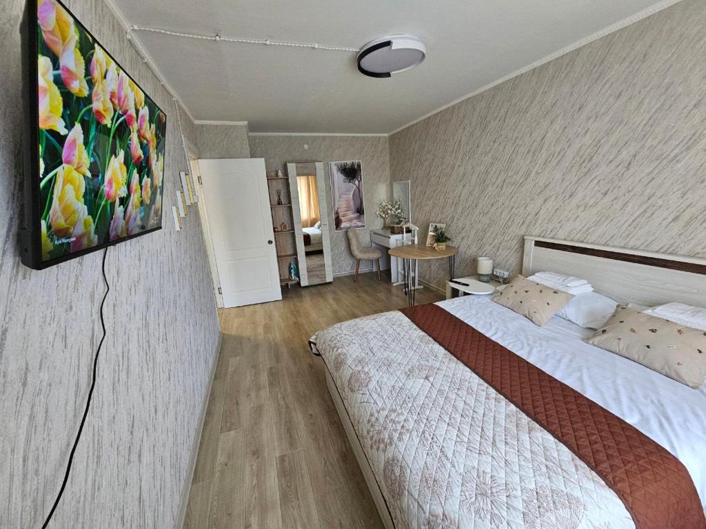 a bedroom with a bed with a painting on the wall at Апартаменти Aura Bliss in Zhytomyr