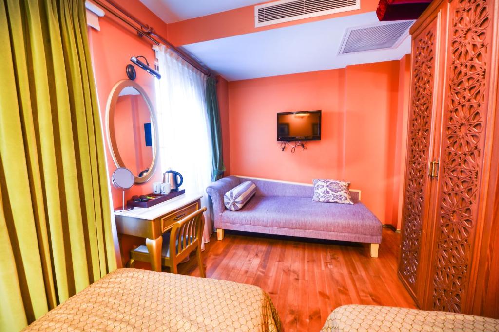 a bathroom with orange walls and a vanity and a sink at Merial Hotel Sultanahmet in Istanbul