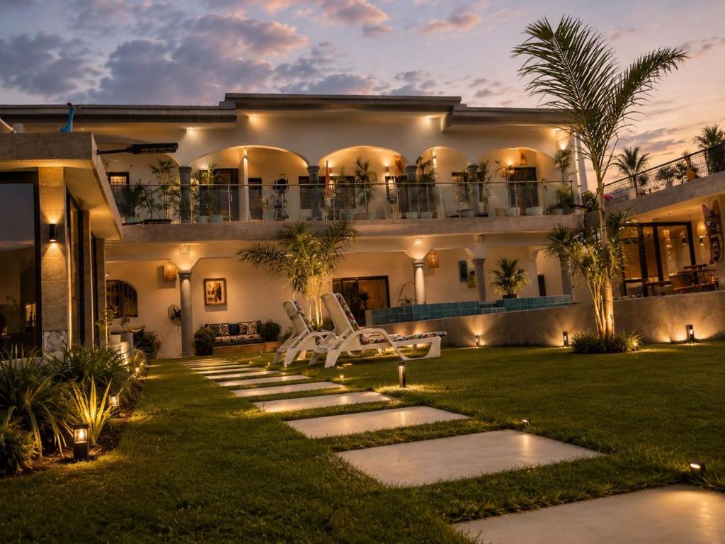 an exterior view of a house with a lawn at Maria Gracia House in Grand-Bassam