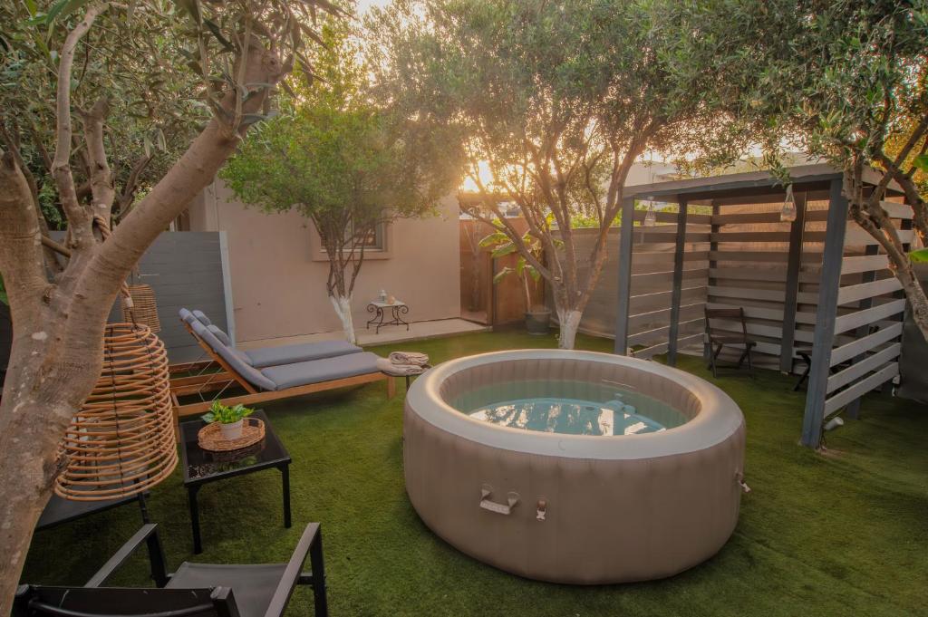 a hot tub in the middle of a yard with trees at Hot Tub - 5 min to Beaches - Private Garden - Netflix in Lampi