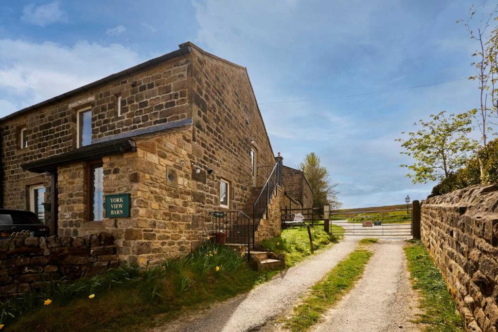 an old brick building on a dirt road at Host & Stay - The Hayloft in Ilkley