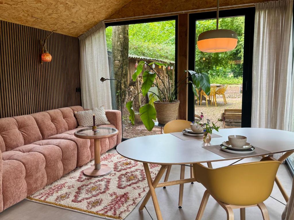 a living room with a pink couch and a table at Tinkerbell in Oosterbeek