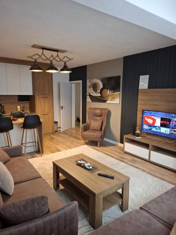 a living room with a couch and a table at Nesi apartmenti in Prishtinë