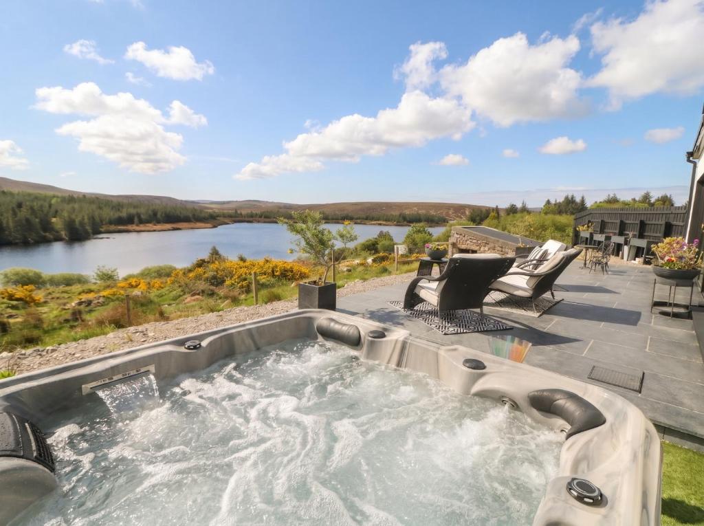 a hot tub on a patio with a view of a river at Hanowen House in Dungloe