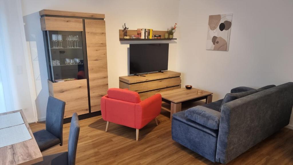 a living room with a couch and a red chair at Rudolph Apartments Kleve in Kleve