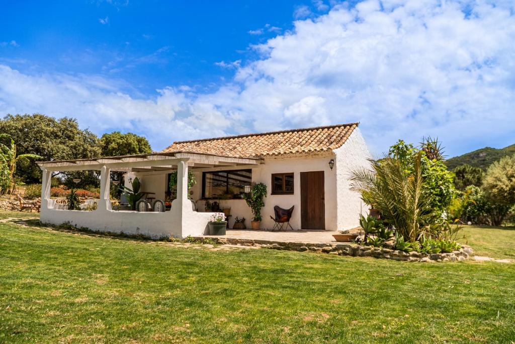 a small white house with a green lawn at Finca Santa Teresa, Casa La Higuera in Casares