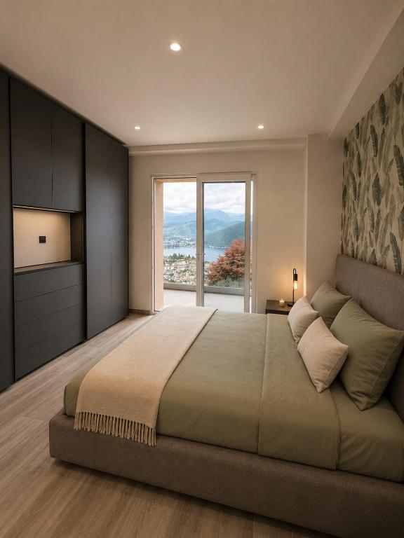 a bedroom with a large bed with a large window at Lake View Apartament 10 - Free Parking & Terrace in Cadegliano Viconago
