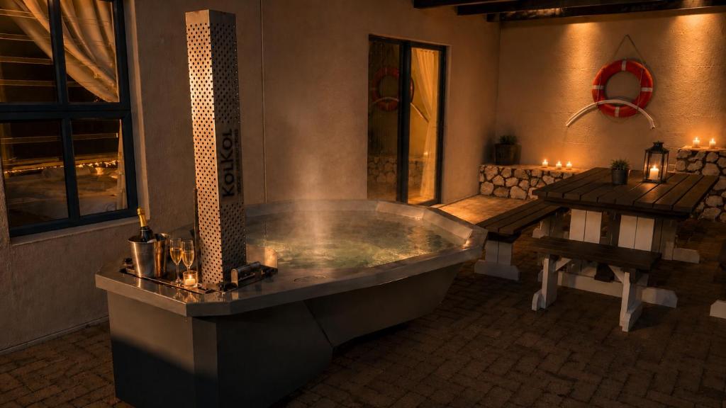 a large bathroom with a tub and a table at Hook Wine And Sinker in Langebaan