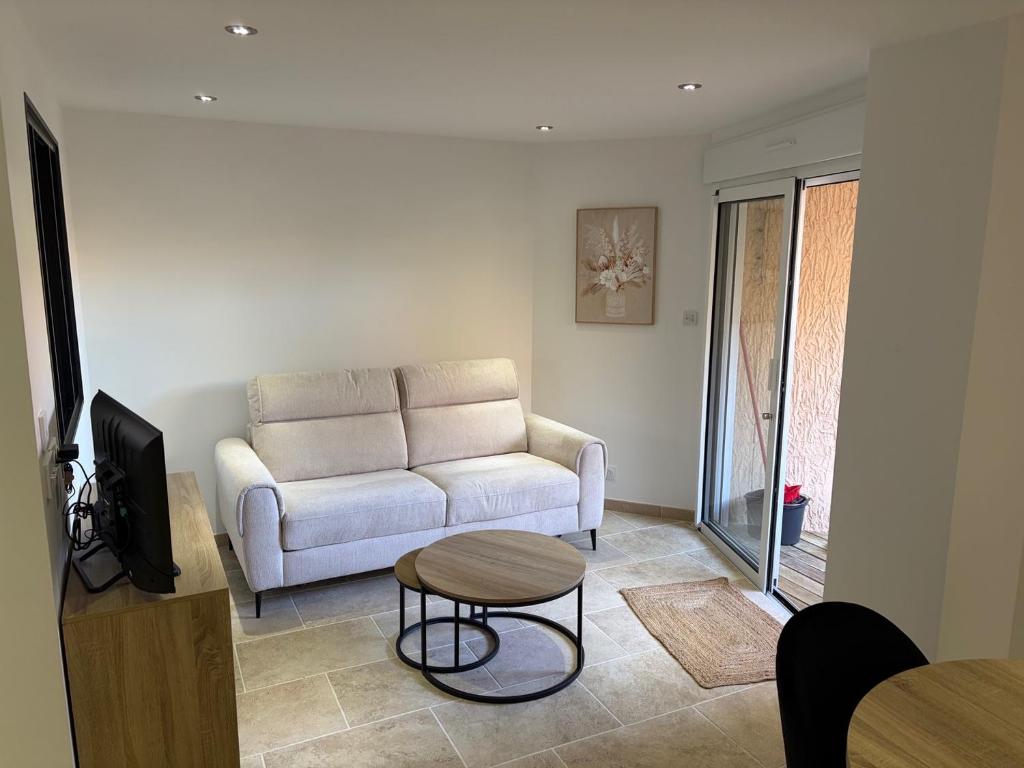 a living room with a couch and a table at Appartement 4 personnes in Sainte-Maxime
