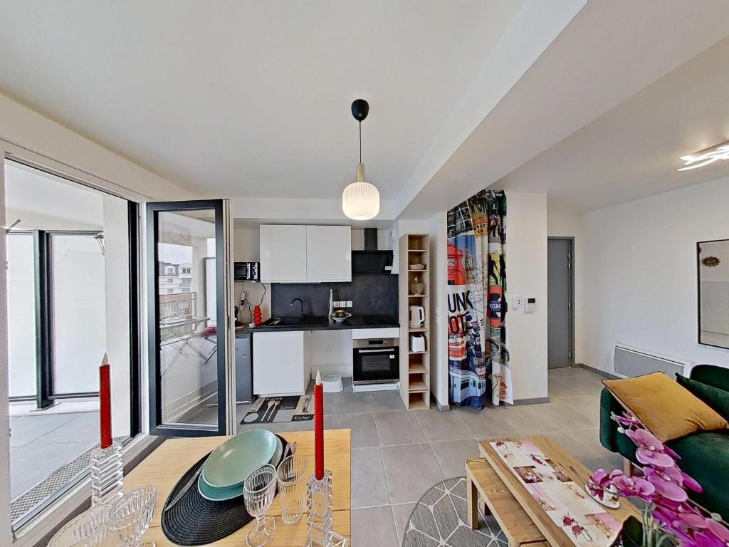 a living room with a couch and a table at Appartement Elégant & Raffiné in Noisy-le-Grand