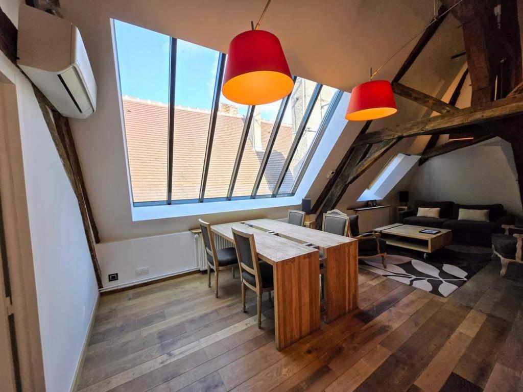 a room with a table and chairs and windows at Robillard 2 - Bail Partner in Auxerre