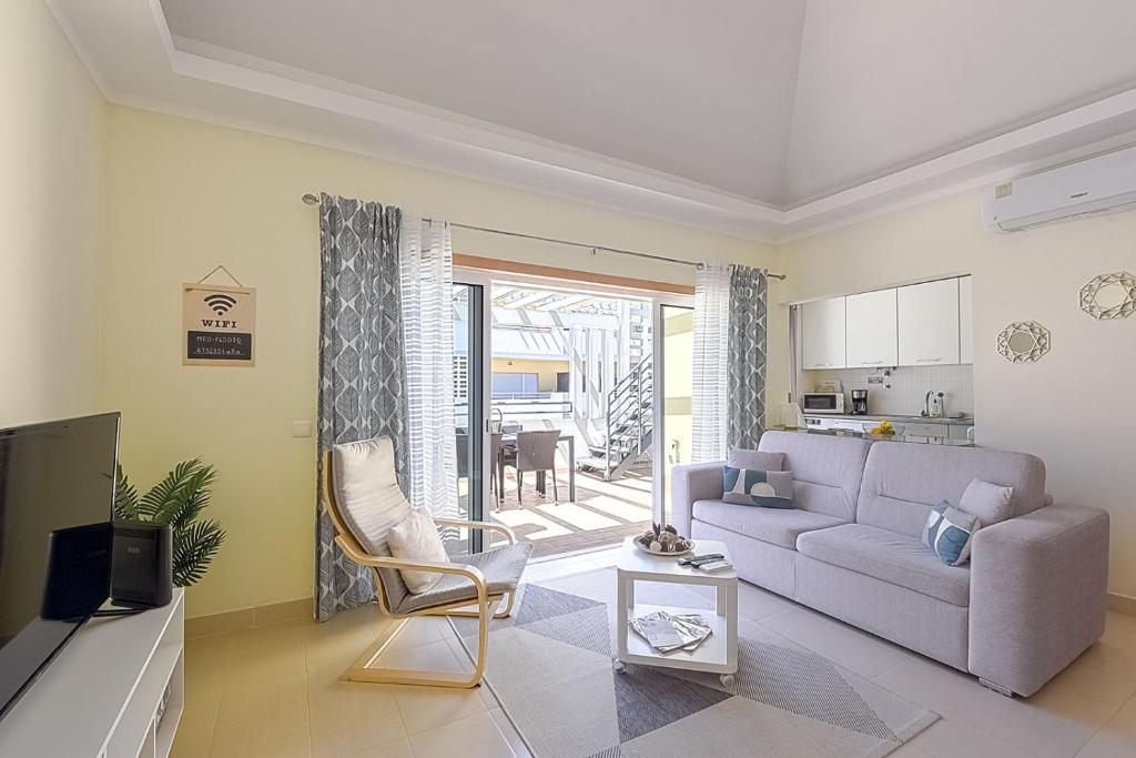 a living room with a couch and a table at Olive Tree penthouse in Tavira