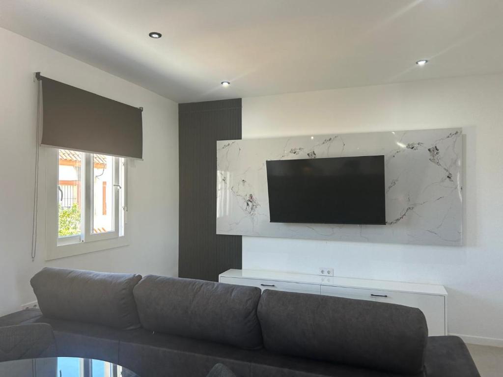 a living room with a couch and a flat screen tv at Atico casa la via in Sanlúcar de Barrameda