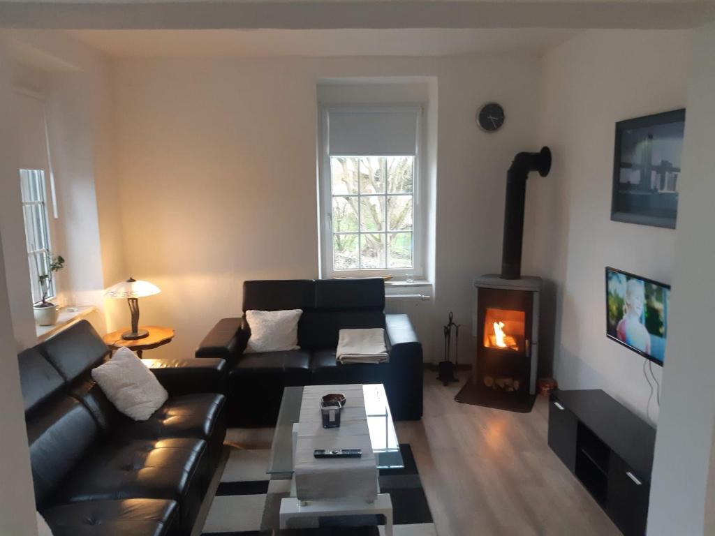 a living room with a couch and a wood stove at Landhaus Sevenich in Münstermaifeld