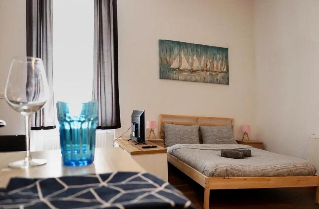 a bedroom with a bed and a table with a wine glass at Hostel Temza in Zagreb