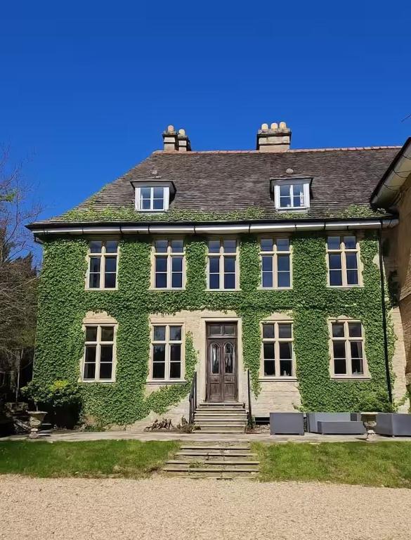 a large green house with stairs in front of it at Russell Hill Manor in Peterborough