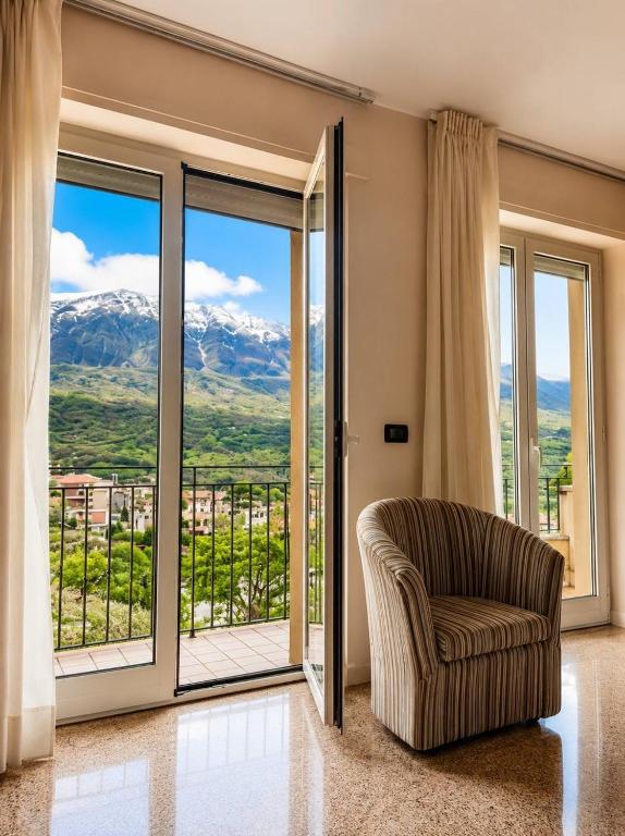 a living room with a chair and sliding glass doors at Hotel Mazzocca in Caramanico Terme