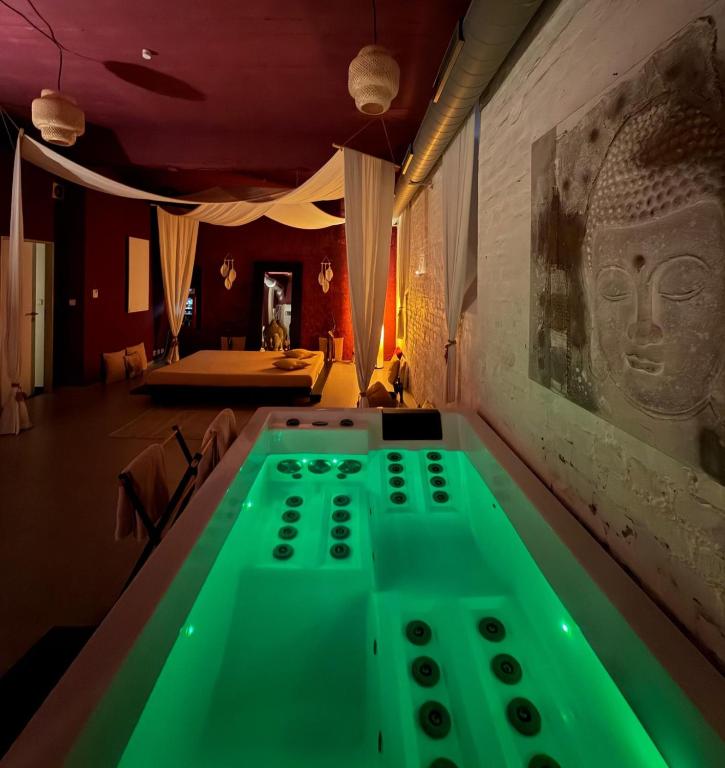 a bath tub with green lighting in a room at iRelax studio - privatni wellness in Prague