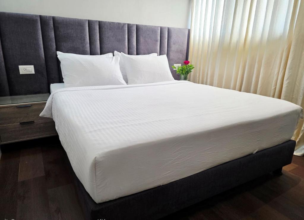 a large bed with white sheets and pillows at Hotel House in Rishon LeẔiyyon