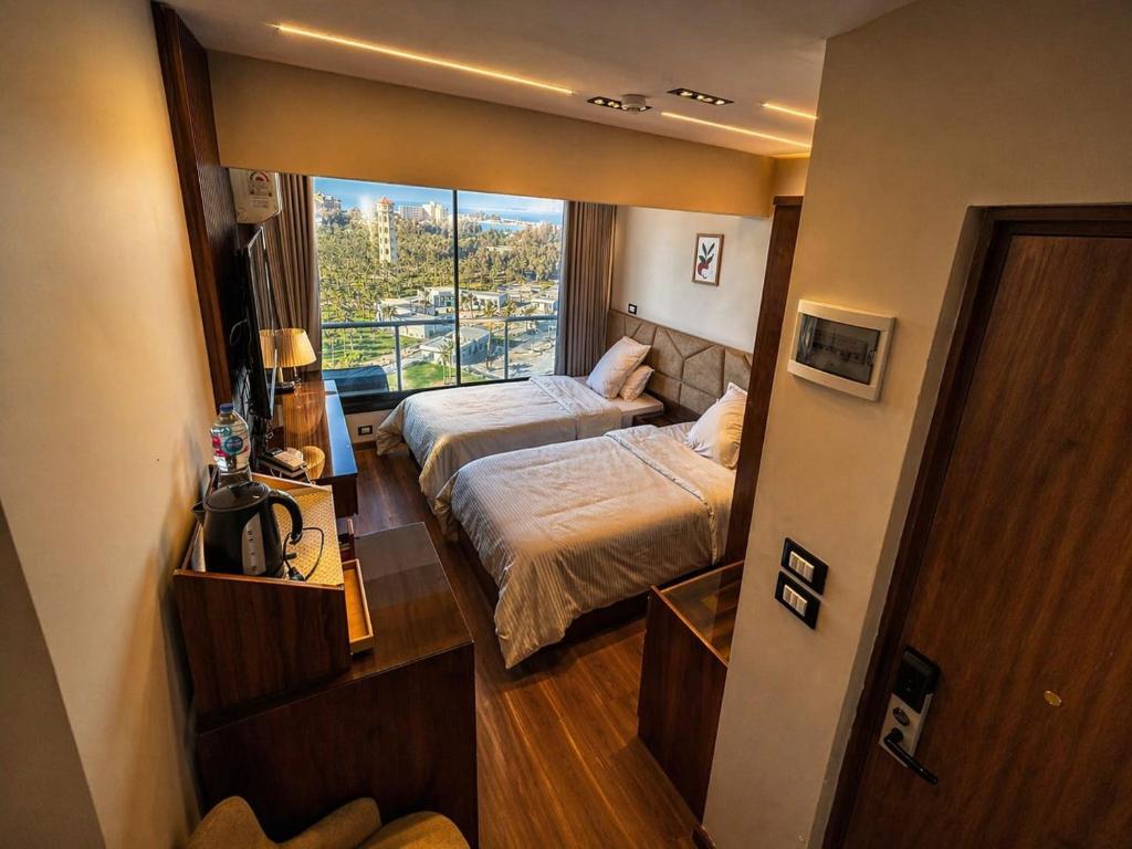 a small room with two beds and a window at Montaza World inn in Alexandria
