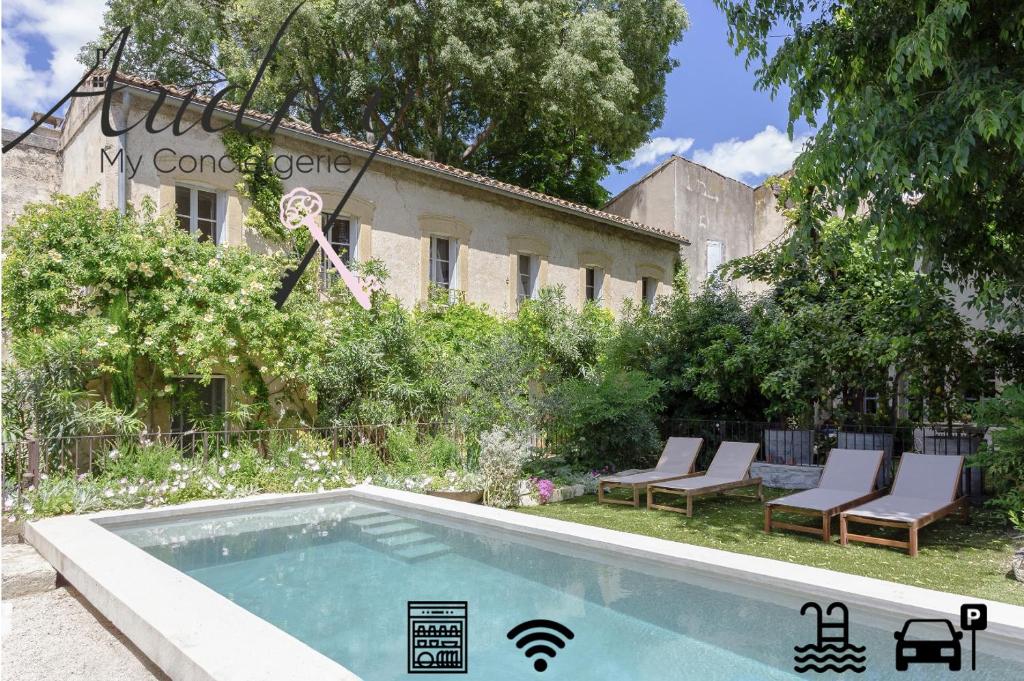 a swimming pool in a yard with chairs and a building at Mas de charme - T2 et chambres d'hôtes avec piscine & jardin in Marsillargues