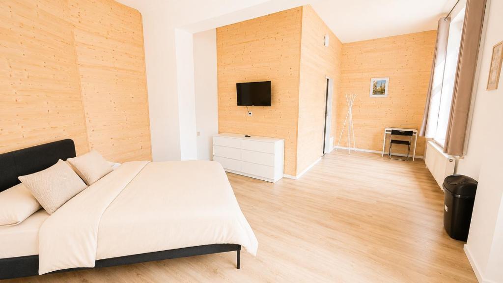 a bedroom with a bed and a tv on a wall at Daubresse 85 A Centre-Gare-Aéroport in Charleroi