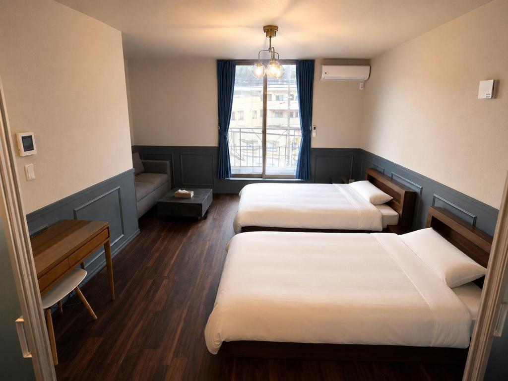 a room with three beds and a window at Telegraph in Kamakura