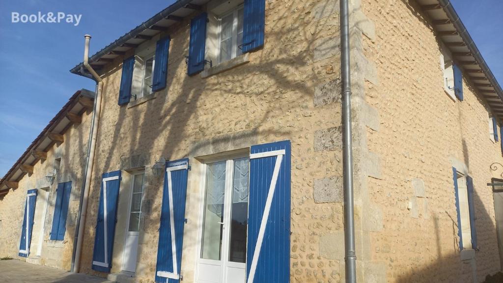 a building with blue windows and blue doors at Eugénie in Saint-Quentin-de-Chalais