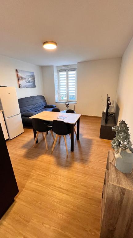 a living room with a table and a couch at Escapade cosy proche nature in Saint Die