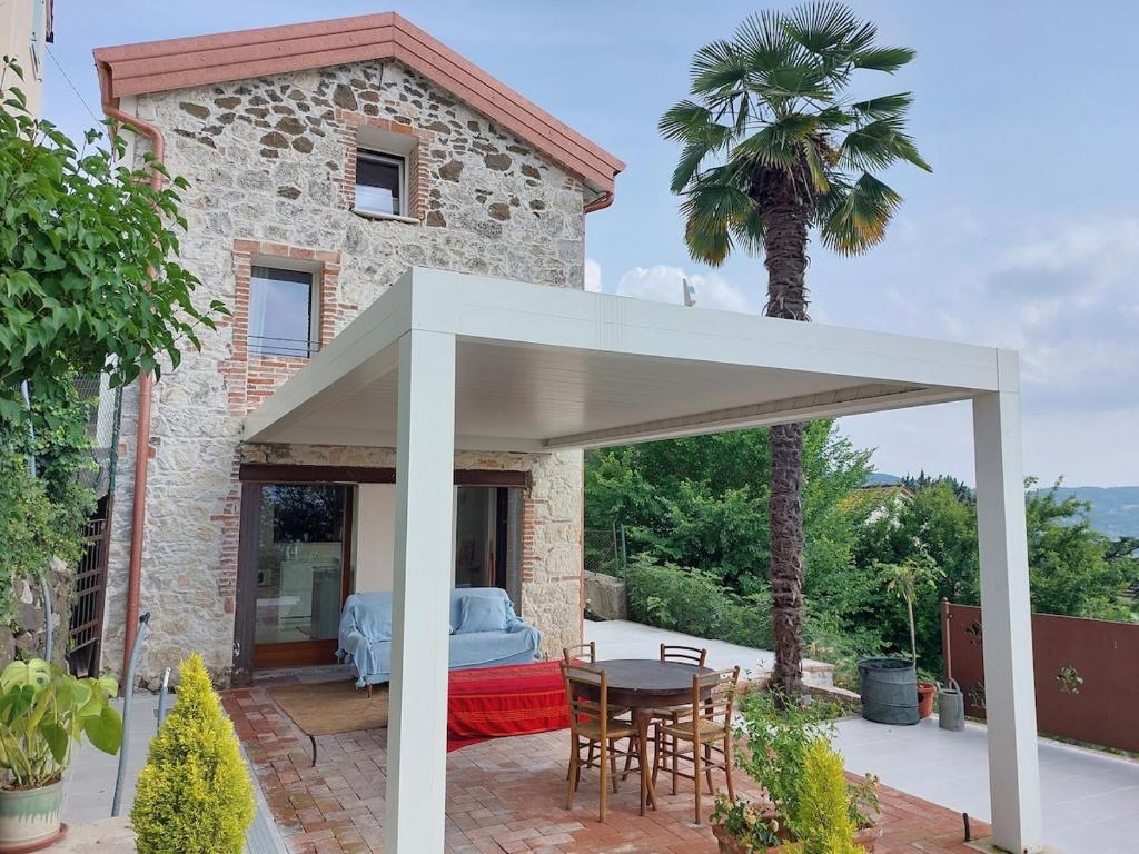 a patio with a white canopy in front of a house at Fairytale old stonehouse in Brendola