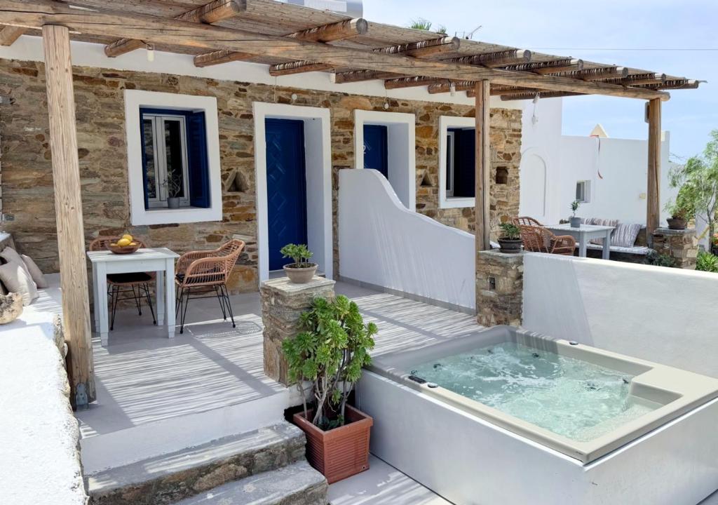 a house with a hot tub on a patio at Aloni Ios in Mylopotas