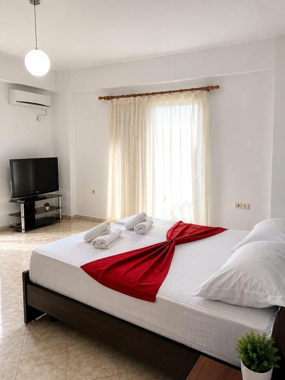 a bedroom with a large bed with a red blanket at Dimora Seaside Apartments in Ksamil