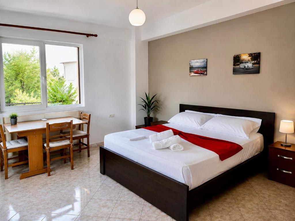 a bedroom with a bed and a table and a desk at VIOLA Seaside Villa in Ksamil