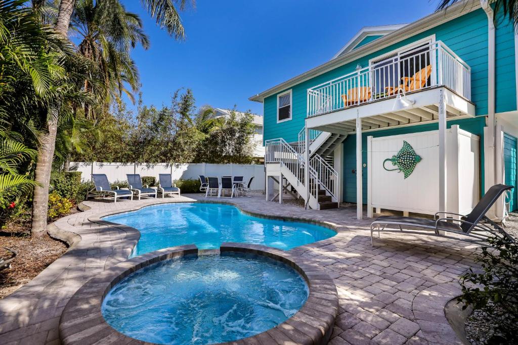 a swimming pool in front of a house at Beach You To It in Anna Maria