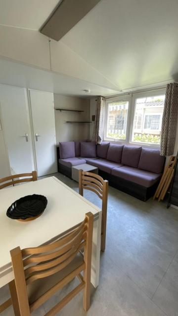 a living room with a couch and a table and chairs at Numero 281 in La Tremblade