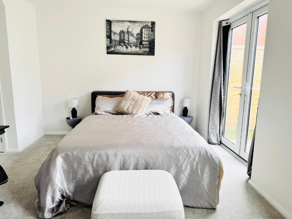 a white bedroom with a bed and a window at Ansari Palace in Worting