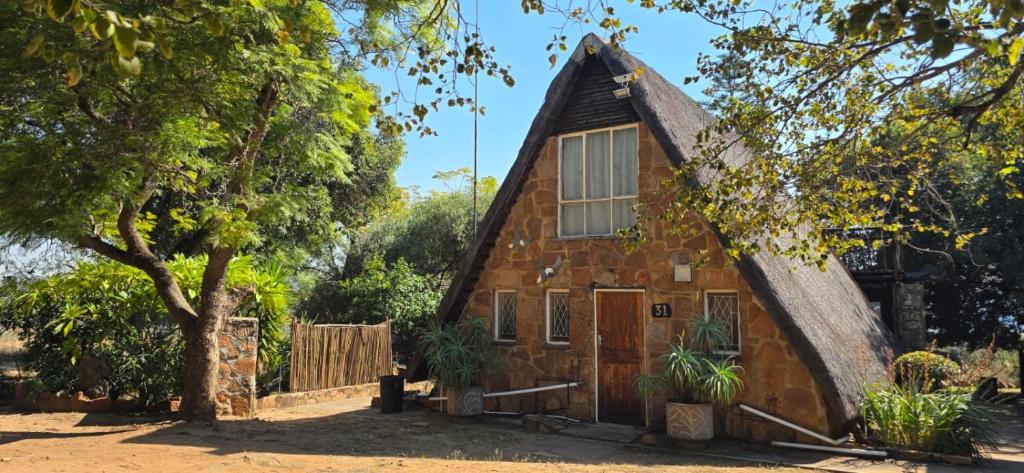 a small house with a thatched roof at Eagles Nest in Rustenburg
