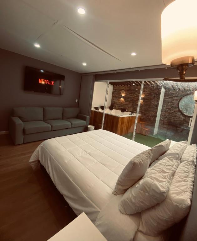a bedroom with a large white bed and a couch at Casa ORO VERDE in San Luis