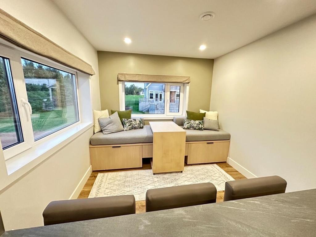 a room with a couch and a table and a window at Opulence Suite-Luxury New Build with Riverview in Montague