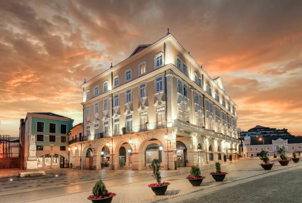 a large white building with potted plants in front of it at TURIM Aveiro Palace Hotel in Aveiro
